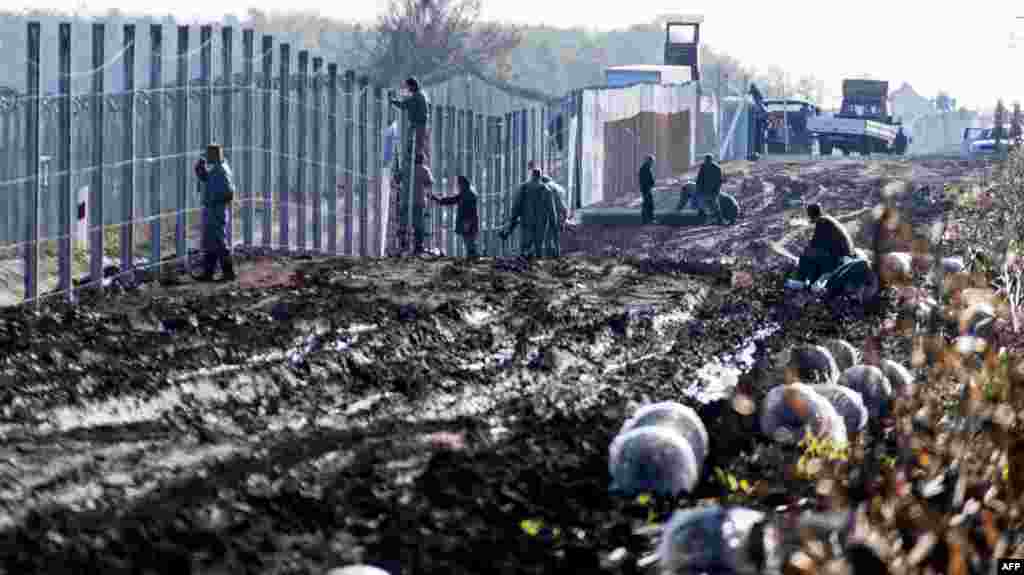 Prisoners build a new, second fence at the Hungarian-Serbian border near Gara village as part of its efforts to keep migrants and refugees from freely entering the country.