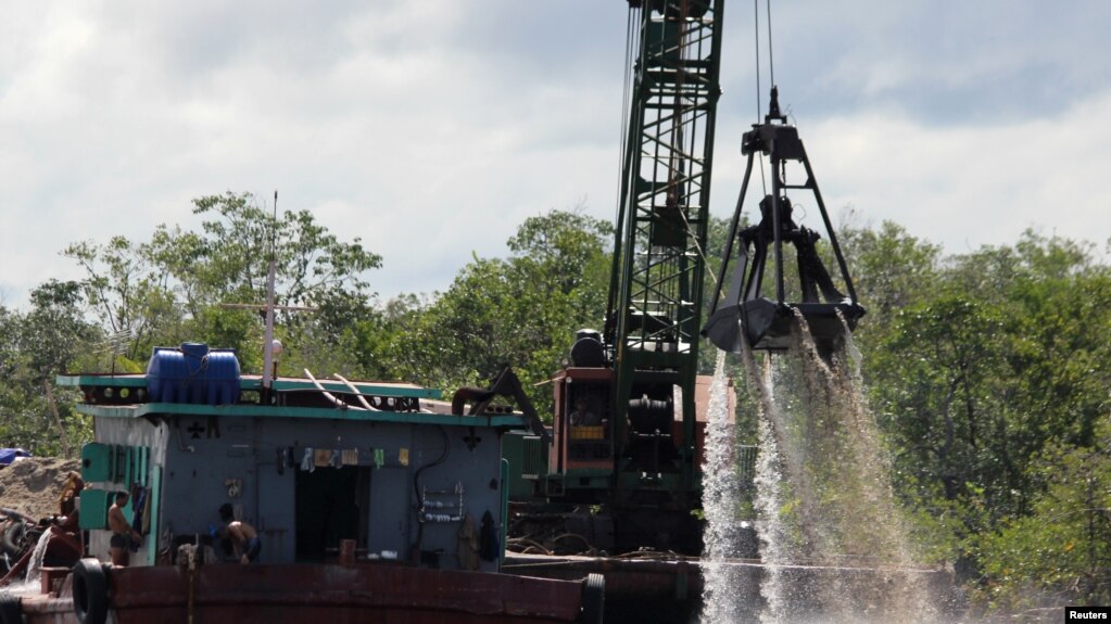FILE PHOTO - Machines pull sand from the bottom of water near Koh Sralau in Cambodia, Oct. 30, 2016.