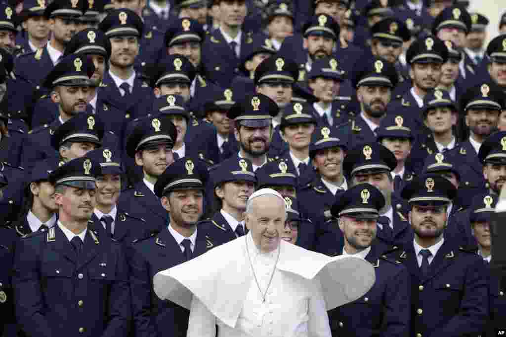 Pope Francis poses with a group of Italian police officers during his weekly general audience, in St. Peter&#39;s Square at the Vatican.