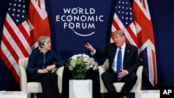 Perezida Donald Trump abonana n'umushikiranganji wa mbere w'Ubwongereza Theresa May mu nama y'ubutunzi, itariki 25/01/2018, i Davos.