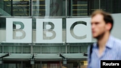 Seorang pejalan kaki berjalan melewati logo BBC di Broadcasting House di pusat kota London, 22 Oktober 2012. (Foto: Reuters)
