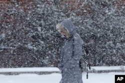 A pedestrian walks through a snowstorm, Jan. 21, 2014, in south Philadelphia.