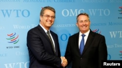 Roberto Azevedo (L), director-general of the World Trade Organization (WTO), greets Britain's International Trade Secretary Liam Fox (R) before a meeting in Geneva, Switzerland, Sept. 27, 2016. 