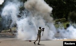 FILE - A journalists runs past a cloud of tear gas after riot police dispersed anti-corruption protesters opposing the graft and abuse of funds in public healthcare, during a demonstration in Kenya's capital Nairobi, Nov. 3, 2016.