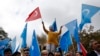 FILE - A child from the Uighur community living in Turkey, who is wearing a mask in the colors of the flag which ethnic Uighurs call East Turkestan and with a painted hand with the colors of China's flag, participates in a protest in Istanbul, Nov. 6, 2018.