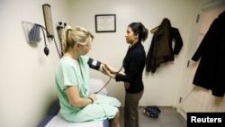 Victoria Will (L) has her blood pressure checked by nurse practitioner Sapana Patel