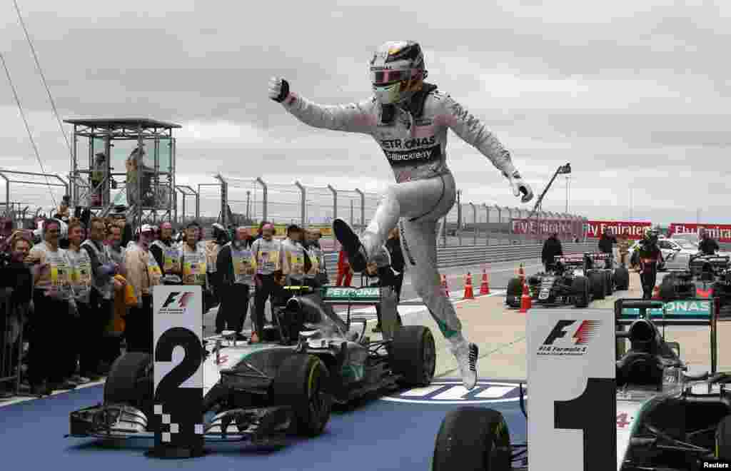 Mercedes Formula One driver Lewis Hamilton of Britain leaps off of his car after winning the U.S. F1 Grand Prix at the Circuit of The Americas in Austin, Texas, Oct. 25, 2015.