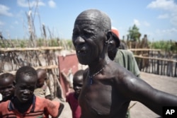 FILE - In this photo taken July 25, 2015, James Gatmai Yoah, in Dablual, South Sudan, who has been living on leaves to survive. His home was burned in a previous attack.