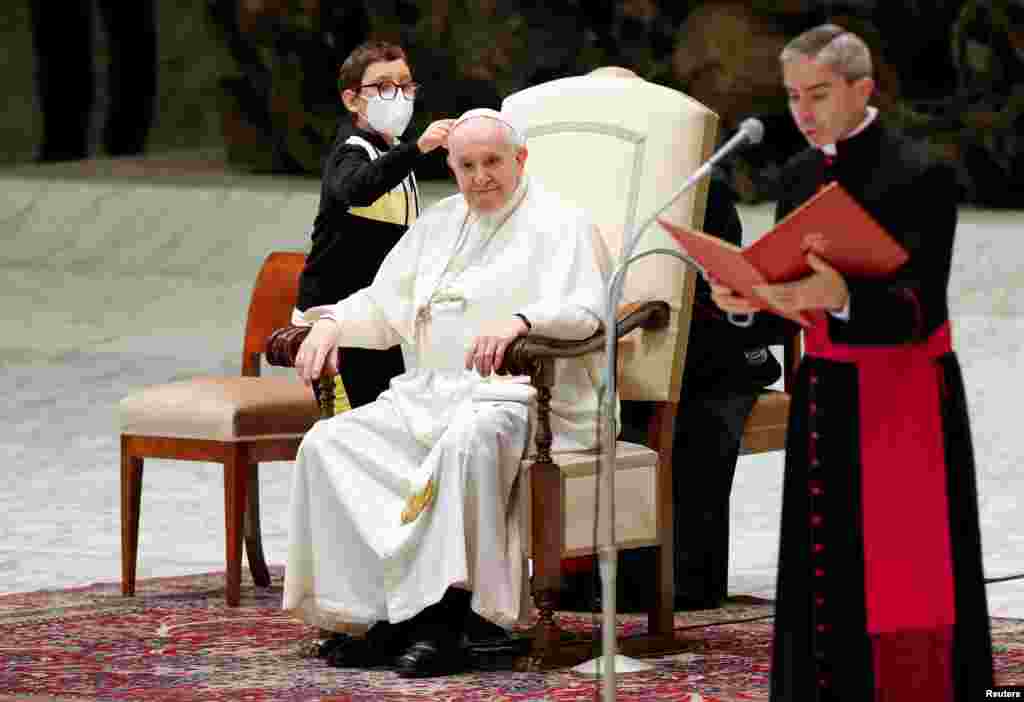 A boy approaches Pope Francis during the weekly general audience at the Vatican.