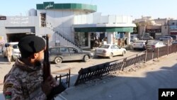 Les soldats de l'armée libyenne montent la garde dans une station-service dans la capitale Tripoli, le 14 décembre 2013.