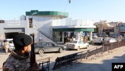 Les soldats de l'armée libyenne montent la garde dans une station-service dans la capitale Tripoli le 14 décembre 2013.