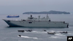 FILE - the Royal Australian Navy HMAS Adelaide cruises alongside landing craft with Philippine Marines and Australian troops as they conduct a joint Humanitarian Aid and Disaster Relief (HADR) exercise off Subic Bay in northwestern Philippines on Oct. 15, 2017. (AP Photo/Bullit Marquez, File)