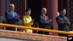Chinese President Xi Jinping (R) applauds with Kazakhstan President Nursultan Nazarbayev (L) South Korea's President Park Geun-hye (S-L) and Russia's President Vladimir Putin (S-R) during a military parade in Beijing, Sept. 3, 2015.
