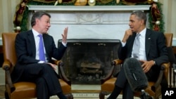 FILE - President Barack Obama meets with Colombian counterpart Juan Manuel Santos at the White House in Washington, Dec. 3, 2013. Santos is scheduled for another visit in February.