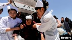 Nurses support an injured woman who is taken to a hospital in Minxian county, Dingxi, Gansu province, July 22, 2013. 