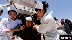 Las enfermeras ayudan a una mujer herida en su traslado al hospital en el condado de Dingxi, en la provincia de Gansu. 