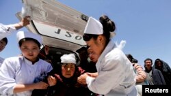 7月22日医护人员从地震现场将一名受伤妇女送往医院