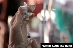 Seorang petugas kesehatan menyiapkan dosis vaksin AstraZeneca dalam program vaksinasi massal untuk Wisata Zona Hijau di Sanur, Bali, 23 Maret 2021. (Foto: REUTERS/Nyimas Laula)
