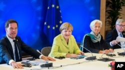 From left, Dutch Prime Minister Mark Rutte, German Chancellor Angela Merkel, Managing Director of the International Monetary Fund Christine Lagarde and European Commission President Jean-Claude Juncker participate in a meeting at an EU summit at the Europ