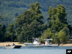 在密苏里州布兰森的桌石湖，紧急救援人员的船只在游船沉没附近的水域巡逻。（2018年7月20日）