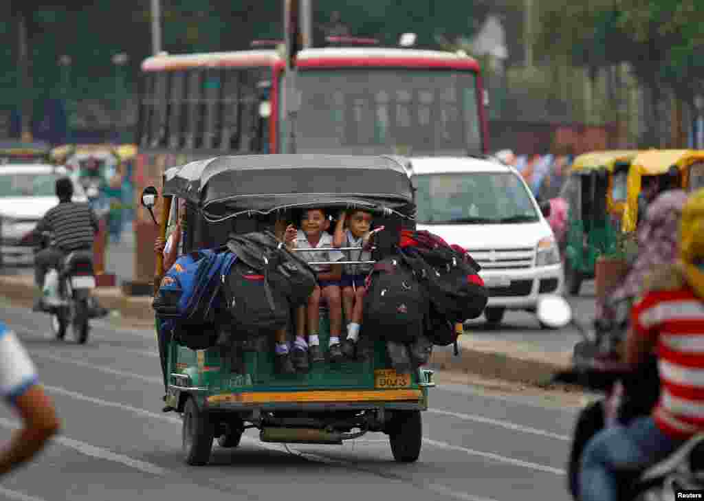 Anal-anak SD berangkat sekolah dengan naik rickshaw di Ahmedabad, India.