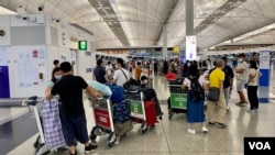 新冠肺炎疫情下冷清的香港國際機場只有前往英國的登機櫃檯排滿移居英國的人潮。（美國之音湯惠芸）