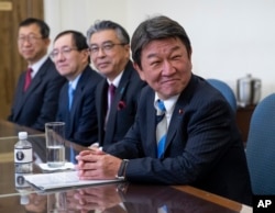 FILE - Toshimitsu Motegi, Japan's minister of economy, trade and industry, smiles as he and U.S. Trade Representative Robert Lighthizer begin ministerial trade talks, at the Office of the U.S. Trade Representative in Washington, Aug. 9, 2018.