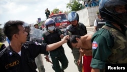 Security forces detain a man during clashes with garment workers in Phnom Penh, Cambodia, Nov. 12, 2013.