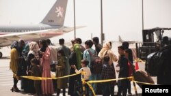 在阿富汗首都喀布爾的哈米德·卡爾扎伊國際機場，平民準備登機。 （2021年8月18日）