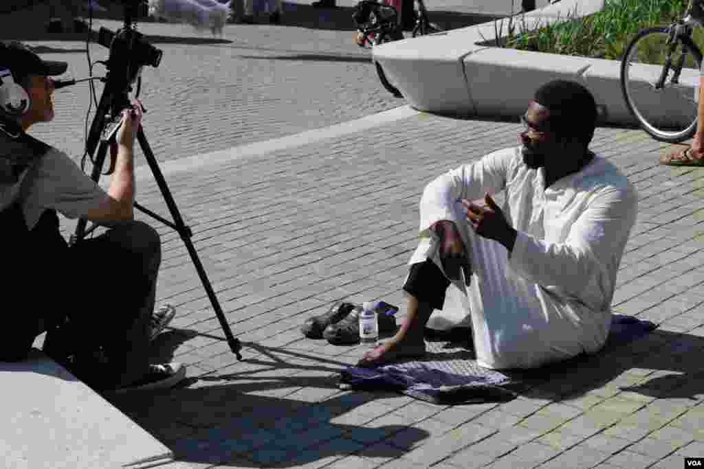 این مرد مسلمان سیاه پوست به اعتراض در مقابل پارک در آفتاب نشسته بود. می گفت ترامپ هم درباره سیاهان و هم درباره مسلمانان اشتباه می کند.