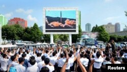 FILE - People watch a huge screen showing the test launch of intercontinental ballistic missile Hwasong-14 in this undated photo released by North Korea's Korean Central News Agency (KCNA), July 5, 2017.