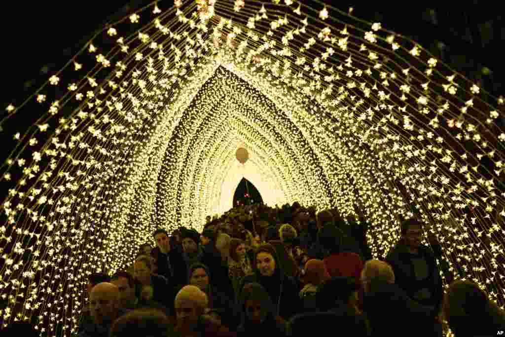 People walk along a light installation during the Bright festival in Brussels, Belgium, February 17, 2019.