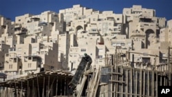 A construction worker works on a new housing unit in the east Jerusalem neighborhood of Har Homa, 08 Dec 2010