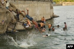 Indian youths cool off in the Ana Sagar lake during a hot day in Ajmer, in Rjasthan state, May 31, 2019. India has been battling a fierce heat wave that has prompted warnings about water shortages and heatstroke.