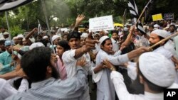 FILE - Indian Muslim men shout slogans during a protest against tensions in India's northeastern state of Assam, in New Delhi, India, Aug. 8, 2012.