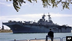 An Egyptian watches US amphibious assault ships USS Kearsarge as it sails at the Suez canal in Ismailia , Mar 2 2011