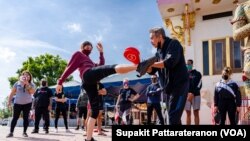 People practice MuayThai with a group of professional MuayThai instructors during a Free Self Defense Muay Thai Class, a martial art training against Asian hate crimes at Wat Thai Los Angeles, April 15, 2021.