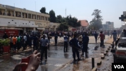 Des pompiers s'activent à éteindre le feu sur trois véhicules endommagés et partiellement incendiés à l'explosion d'une grenade près de la Banque commerciale Kenya à Bujumbura, Burundi vendredi 29 mai 2015. (Edward Rwena - VOA