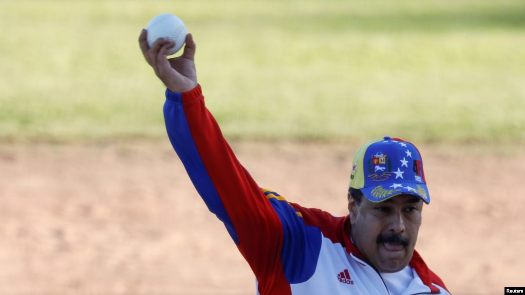 Venezuela's President Nicolas Maduro throws the ball during a softball game with ministers and military high command members at Fuerte Tiuna military base, in Caracas, Venezuela, Jan. 28, 2018.