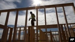 FILE - Construction worker Elabert Salazar works on a house frame for a new home in Chula Vista, California, Nov. 16, 2012.