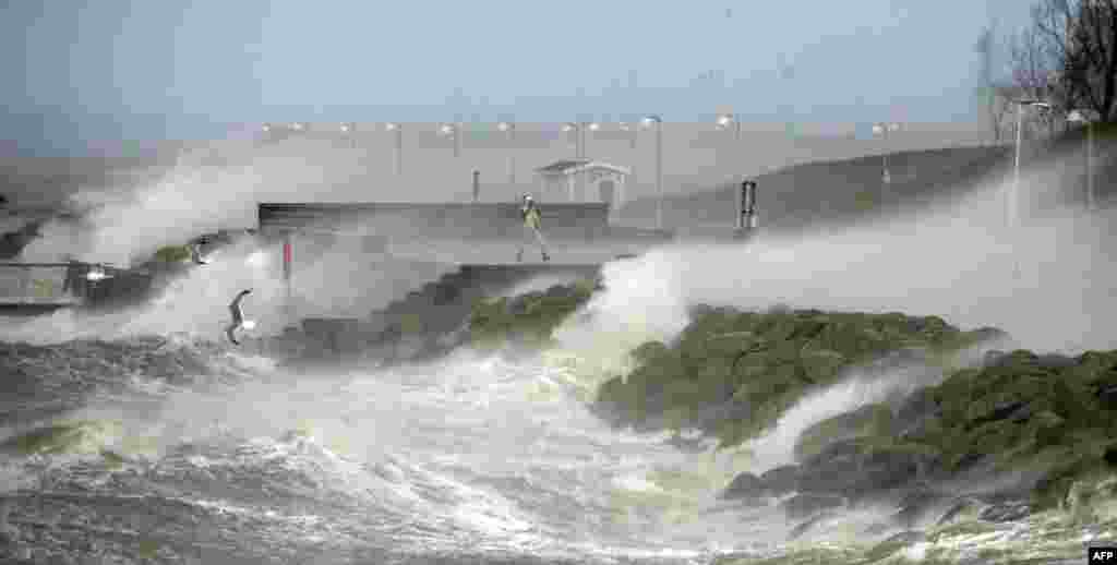 A storm spotter stands on the sea front in Malmo, southern Sweden. Winter storm Xaver claimed one life, littered roads with uprooted trees, stalled trains, and left tens of thousands without power.