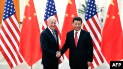 Chinese President Xi Jinping (R) shakes hands with US Vice President Joe Biden (L) inside the Great Hall of the People in Beijing on December 4, 2013 AFP PHOTO / POOL (Photo by LINTAO ZHANG / POOL / AFP)