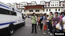 Sebuah van polisi Singapura siaga sementara para sopir bus asal Tiongkok melakukan aksi mogok di Singapura (26/11).