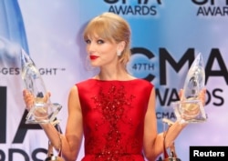 Taylor Swift poses with her CMA Pinnacle award as well as awards for Musical Event of the Year and for Music Video of the Year, both of the latter for "Highway Don't Care," with Tim McGraw and Keith Urban, at the 47th Country Music Association Awards in N