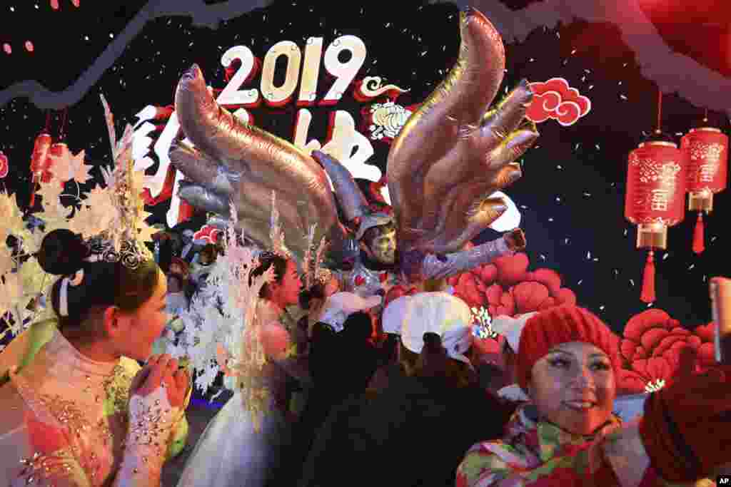 Performers take selfies at the end of a countdown to the new year event in Beijing, China, Jan. 1, 2019.