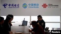 資料照：2018年11月5日在上海舉行的中國國際進口博覽會上顯示的中國電信、中國移動和中國聯通的標誌。