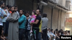 Des gens font la queue pour avoir du pain à Al-Shaar, un quartier d'Alep contrôlé par les rebelles, en Syrie, le 14 juillet 2016.