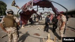 Iraq security forces gather at the site of a suicide bomb attack in Baghdad, Iraq, Oct, 16, 2016. 