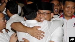 Gubernatorial candidate Anies Baswedan, center right, hugs his running mate Sandiaga Uno during a press conference in Jakarta, Indonesia, April 19, 2017. 