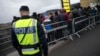 Arhiva - Švedski policajac posmatra dok migranti doazle na stanicu Hajlie u predgrađu Malmea, Švedska.